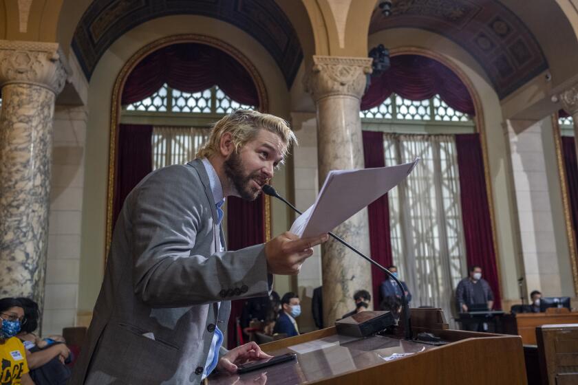 LOS ANGELES, CA - MAY 04: Ricci Sergienko attempts to serve Councilman Paula Koretz with papers during the Los Angeles City Council meeting at City Hall on Wednesday, May 4, 2022 in Los Angeles, CA. Sergienko was asked to leave the meeting following his public comment period. He continues to yell at Councilman Joe Buscaino. Today the public were allowed inside City Hall for the first time since March 2020 due to the coronavirus pandemic. (Francine Orr / Los Angeles Times)