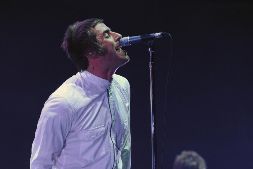 Liam Gallagher, left, and his brother Noel Gallagher perform onstage