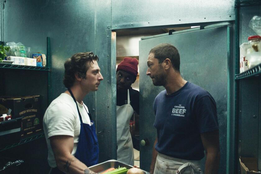 Two men in a restaurant cold storage locker, with a third man peering in through the door