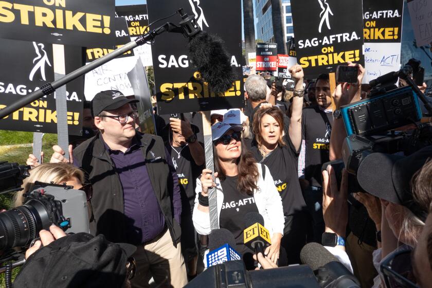 LOS ANGELES, CA - JULY 14: SAG-AFTRA President Fran Drescher and National Executive Director and Chief Negotiator Duncan Crabtree-Ireland, left, greet picketers at the Netflix picket line in Los Angeles, CA on Friday, July 14, 2023. Actors join striking writers who have been on the picket lines since the beginning of May. (Myung J. Chun / Los Angeles Times)