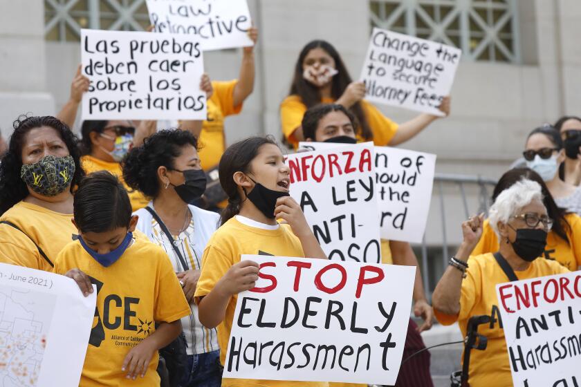 LOS ANGELES, CA - AUGUST 06: Gustavo Rangel, 10, center, with brother Gael Rangel, 9, and their Mother Maria Rangel join members of Alliance of Californians for Community Empowerment rally to mark the first day of enforcement of Los Angeles' anti-tenant harassment ordinance. Tenants' rights advocates and their supporters participated in the rally to celebrate the ordinance, as well as urge the L.A. City Council to make amendments such as making it retroactive, which supporters believe will "hold landlords accountable to all abuse, not just incidents happening after August 6." City Hall on Friday, Aug. 6, 2021 in Los Angeles, CA. (Al Seib / Los Angeles Times).