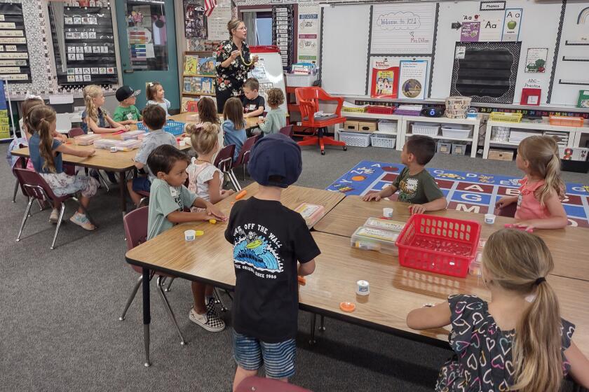 Barnett Elementary kindergarten teacher Jill Dillon leads her class in shaping the letter “s” for snake out of clay.