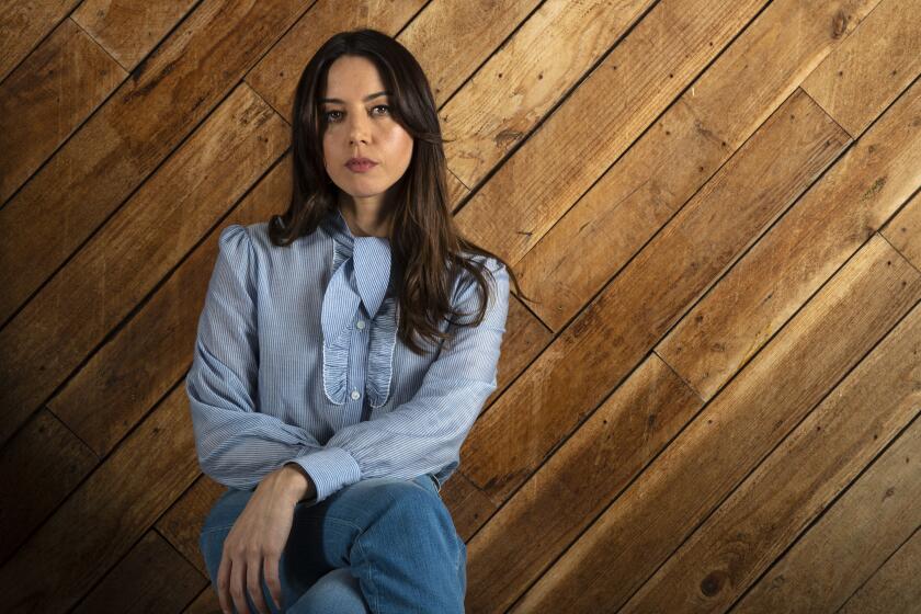 Aubrey Plaza sits in navy pinstripe blouse and jeans for portraits at the Hotel Covell, Nov. 17, 2020 in East Hollywood