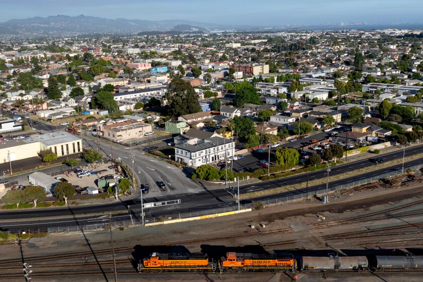 RICHMOND, CALIFORNIA - JUNE 18: In this aerial view, a train motors through a section of Richmond, California on June 18, 2024. The city of Richmond, California is considering a tax that will cost Chevron $1 per barrel and will raise approximately $30-$50 million. Supporters of the tax say Chevron is poisoning their air and causing local residents to get sick. Chevron says the city is trying to make up for budget shortfalls and will cost everyone more at the pumps. (Josh Edelson / For the Times)