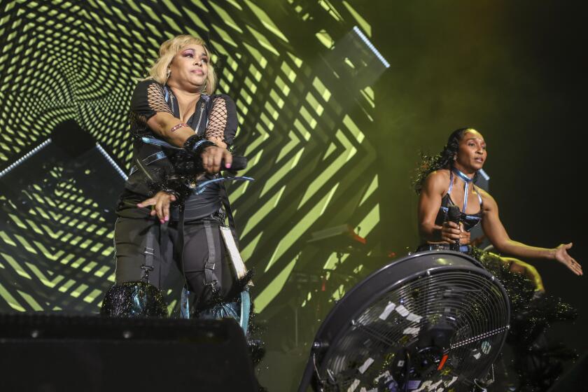 TLC perfomring on a stage with green lights