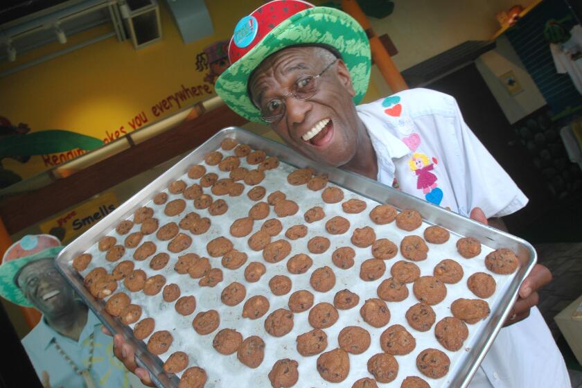 FILE - This Tuesday, June 12, 2007, file photo shows Wally Amos, of Kailua, Hawaii, in his home office in the Lanikai section of Kailua, Hawaii. The Hawaii man, who in the 1980s lost ownership of his Famous Amos cookie company, is now selling his cookies at candy store Boardwalk Treats under the name, The Cookie Kahuna. (AP Photo/Lucy Pemoni)