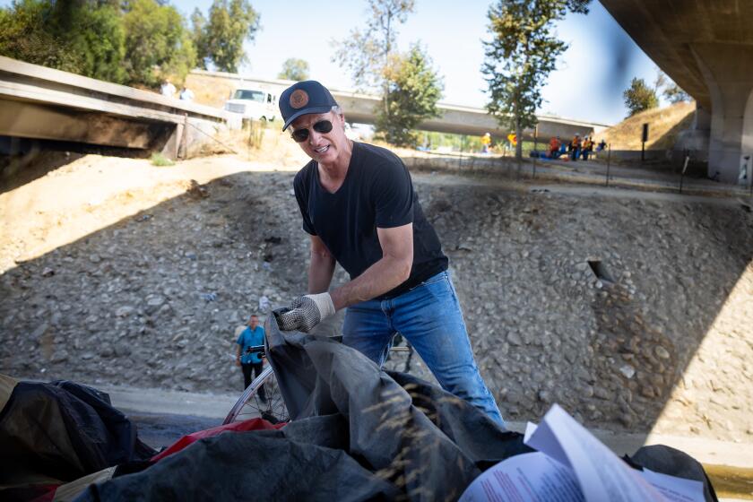 Los Angeles, CA - August 08: Governor Gavin Newsom along with Caltrans clean up an encampment site near Paxton Street and Remick Avenue in Los Angeles as the state's Clean California initiative continues on Thursday, Aug. 8, 2024 in Los Angeles, CA. (Jason Armond / Los Angeles Times)